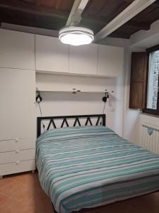 a bedroom with a bed with a striped comforter at A Casa di MaPe in Viterbo