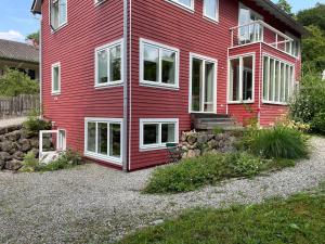 a red house with white windows on the side of it at Ferienwohnung am Kienbach in Herrsching am Ammersee