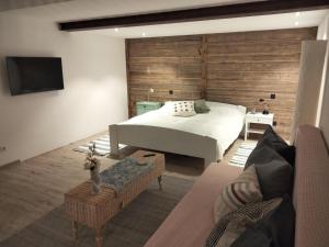 a bedroom with a bed with a wooden wall at Ferienwohnung am Kienbach in Herrsching am Ammersee