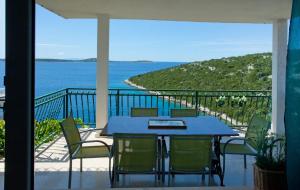 a blue table and chairs on a balcony with the ocean at Apartments Paradise With Amazing Sea View in Vinišće