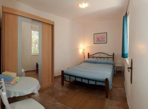 a bedroom with a bed and a chair in it at Apartments Paradise With Amazing Sea View in Vinišće