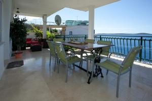 a table and chairs on a balcony with a view of the water at Apartments Paradise With Amazing Sea View in Vinišće