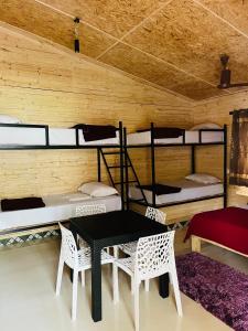 a room with bunk beds and a table and chairs at Kodai Elegance in Kodaikānāl