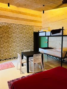 a room with a table and chairs and bunk beds at Kodai Elegance in Kodaikānāl