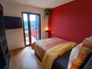 a bedroom with a bed and a red wall at RED House Rabac in Rabac +10 photos