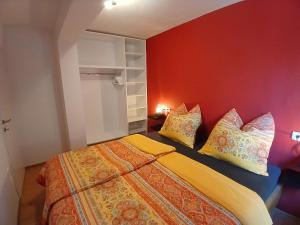 a bedroom with a bed with pillows and a red wall at RED House Rabac in Rabac