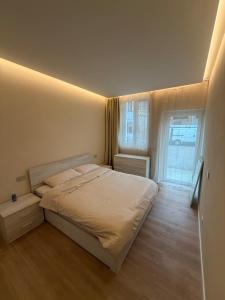 a bedroom with a white bed and a window at Milan house 2 in Samarate