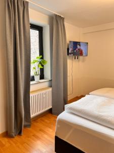 a bedroom with a bed and a window with a tv at City Apartment 1 in Euskirchen