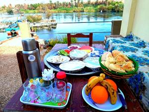 a table with plates of food and fruit on it at Shellaly Ca Nubian Guest2 House in Jazīrat Salūjah +18 photos