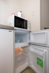 an open refrigerator with a microwave on top of it at Mi-Hotel Nakano- Shinjuku Direct 中野南台 in Tokyo