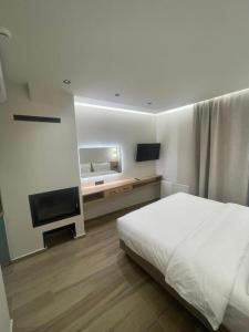 a bedroom with a bed and a flat screen tv at Tasia Mountain Hotel in Chania
