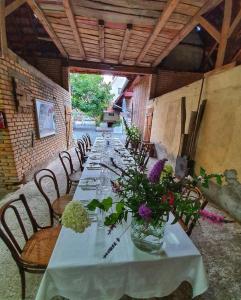 a long table with vases of flowers on it at Appartement cosy au calme avec sauna in Kauffenheim +36 photos