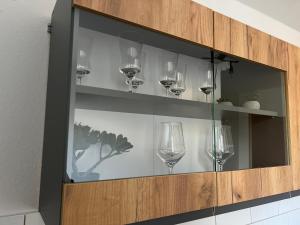 a glass cabinet with wine glasses in it at City Apartment 1 in Euskirchen +19 photos