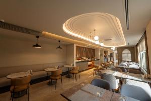 a restaurant with tables and chairs in a room at Reiwa Business Hotel in Osmaniye