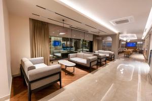 a waiting room with couches and chairs in a building at Reiwa Business Hotel in Osmaniye