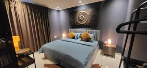 a bedroom with a bed with blue sheets and yellow pillows at Maison Miraj Hostel in Muscat