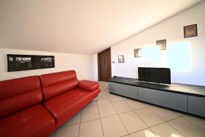 a living room with a red couch and a flat screen tv at La Terrazza Sidicina Home in Teano