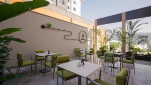 a restaurant with tables and chairs and a clock on the wall at Reiwa Business Hotel in Osmaniye