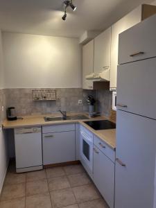 a kitchen with white cabinets and a white refrigerator at Villa Nikki in Bilice