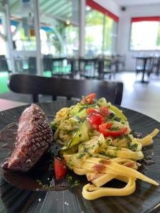 a plate of food with meat and vegetables on a table at Logis Hotel Noemys Brive - Restaurant Le Teinchurier in Brive-la-Gaillarde