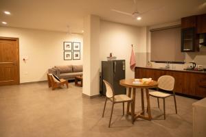 a kitchen and living room with a table and a refrigerator at Ara Ki Serviced Apartments in Kohīma