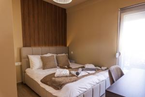 a bedroom with a large bed with towels on it at Asana luxury apartment in Kozani