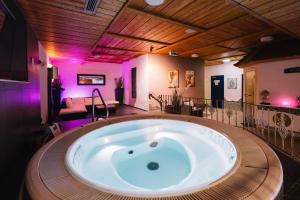 a large bath tub in a room with purple lights at hotel zentlinde in Mossautal