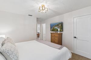 a white bedroom with a bed and a tv at Harbour Oaks, Unit 618 in Saint Simons Island +13 photos