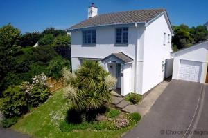 a white house with a palm tree and a driveway at CROYDE WHITE HOUSE 4 Bedrooms in Croyde