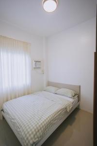 a bed in a white room with a window at Villa Serena in Dauis +26 photos