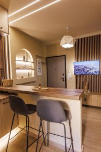 a kitchen with two bar stools at a counter at Asana luxury apartment in Kozani +38 photos