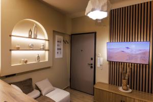 a room with a bed and a tv and a door at Asana luxury apartment in Kozani
