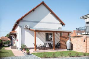 a detached house with a conservatory and a patio at Mona Apartman in Sárvár