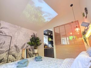 a bedroom with a bed with blue towels on it at L'Évasion Tropicale, Queen Size, Jardin & Gare in Saint-Brieuc
