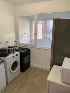 a kitchen with a washing machine and a window at Charming, comfortable 3-room apartment in Ronchin