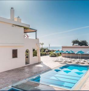 a villa with a swimming pool next to a building at Amaryllis front beach hotel in Lartos