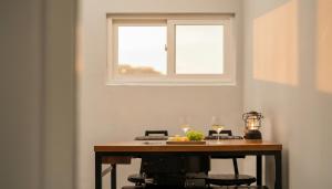 a table with two wine glasses and a window at Gyeongju Modern Pool Villa in Gyeongju