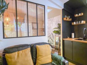 a living room with a couch and a sink at L'Évasion Tropicale, Queen Size, Jardin & Gare in Saint-Brieuc