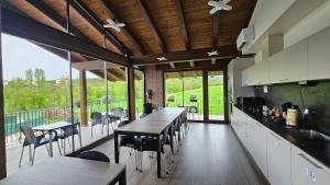 a large kitchen with tables and chairs and a balcony at Casa Nahia Hostal Rural in Lorca