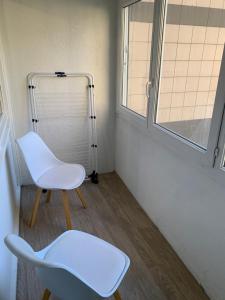 a white chair in a room with a window at Charming, comfortable 3-room apartment in Ronchin