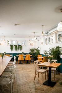 a restaurant with tables and chairs and plants at Hotel Villa Baltica in Sopot