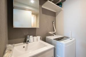 a small bathroom with a sink and a washing machine at Mi-Hotel Nakano- Shinjuku Direct 中野南台 in Tokyo +45 photos
