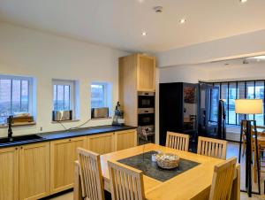 a kitchen with a wooden table and a dining room at Hotel B&R Piano 2 - Louvain-la-Neuve - Mont Saint Guibert in Louvain-la-Neuve