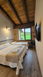 a bedroom with two beds and a tv and a window at Casa Nahia Hostal Rural in Lorca