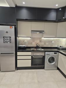a kitchen with a refrigerator and a stove and a dishwasher at Nouvel appartement élégant à Cabo - Vue sur la piscine et proche de la plage in Cabo Negro