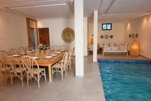 a dining room with a table and a swimming pool at Casa Bianca in Marrakesh