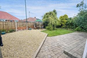 a backyard with a fence and a brick patio at 3 Bed Bungalow with Large Garden in Westoe +12 photos