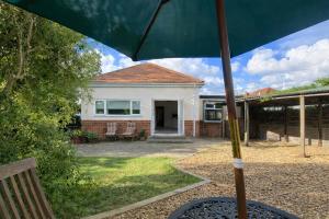 a house with an umbrella in front of it at 3 Bed Bungalow with Large Garden in Westoe