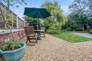 a patio with a table and chairs and an umbrella at 3 Bed Bungalow with Large Garden in Westoe