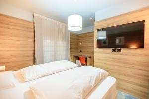 a bedroom with two beds and a flat screen tv at Ferrucci Rooms in Marina di Cecina